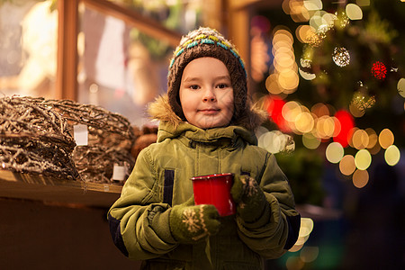 假期,童人们的快乐的小男孩诞市场冬天的晚上喝茶快乐的男孩诞市场喝杯茶图片