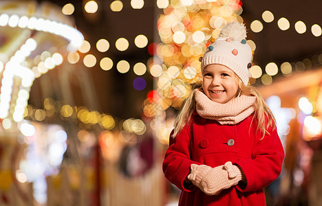 假期,童人的快乐的小女孩诞市场冬季晚上冬天诞节市场上快乐的小女孩图片