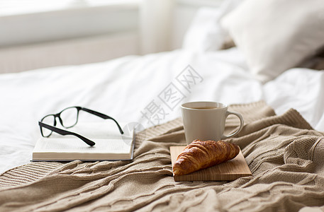 舒适,潮湿内部咖啡,牛角包,毯子书籍床上舒适的家家里的咖啡,毯子床上的书图片