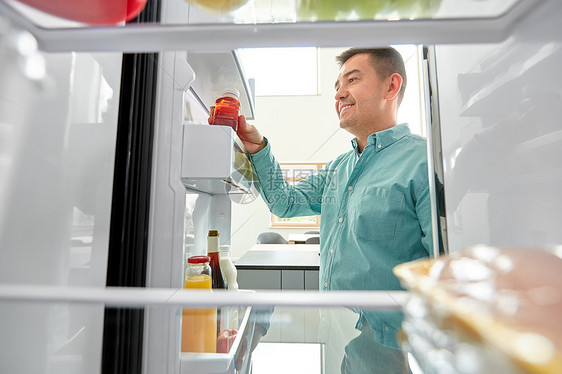 健康的饮食,食物饮食中男子冰箱家里厨房瓶果汁男人家里厨房的冰箱里果汁图片