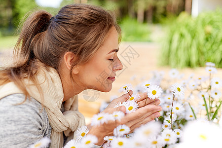 女人闻着洋甘菊花图片