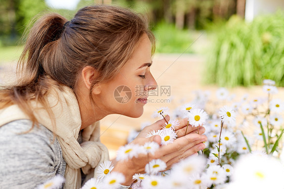 女人闻着洋甘菊花图片