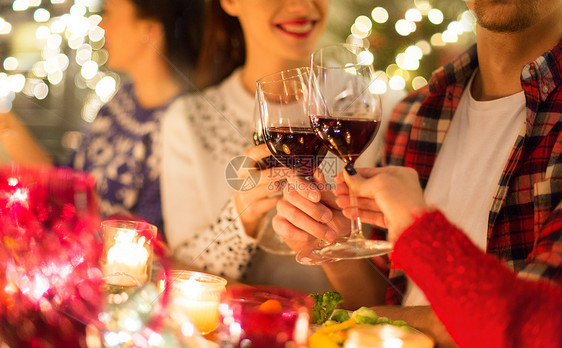 节日庆祝亲密的快乐朋友家里吃诞晚餐,喝红酒碰杯亲密的朋友用葡萄酒庆祝诞节图片