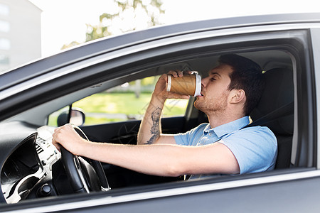 疲惫的困乏男子汽车司机开车喝咖啡图片