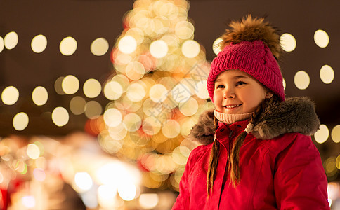 冬季晚上诞节市场上快乐的小女孩图片