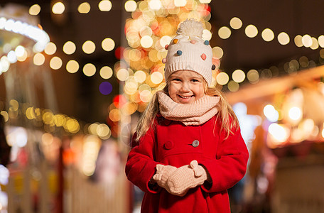 假期,童人的快乐的小女孩诞市场冬季晚上冬天诞节市场上快乐的小女孩图片