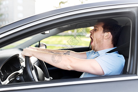 疲倦困倦的男人司机开车打哈欠高清图片