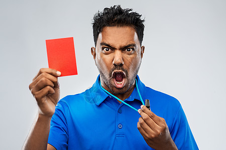 运动,谨慎,游戏足球愤怒的印度男裁判用口哨出示红色点球卡愤怒的印度裁判哨子红牌背景图片