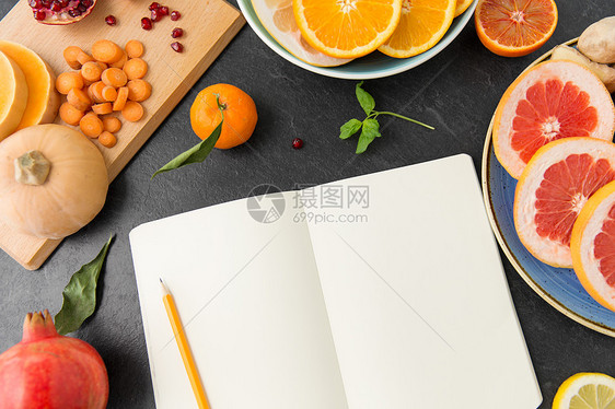 石板桌上的笔记本水果蔬菜图片