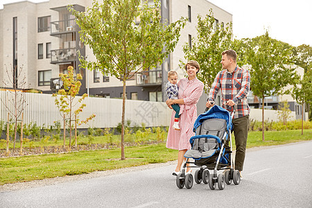 家庭父母带着婴儿婴儿车沿着城市行走背景图片