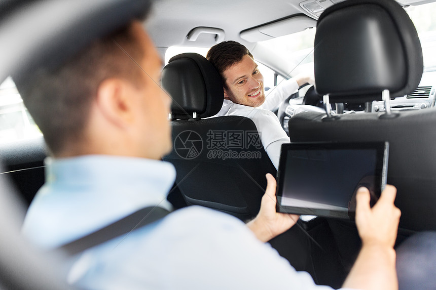 交通,车辆人的男汽车司机看着乘客与平板电脑坐后座男汽车司机乘客与平板电脑图片