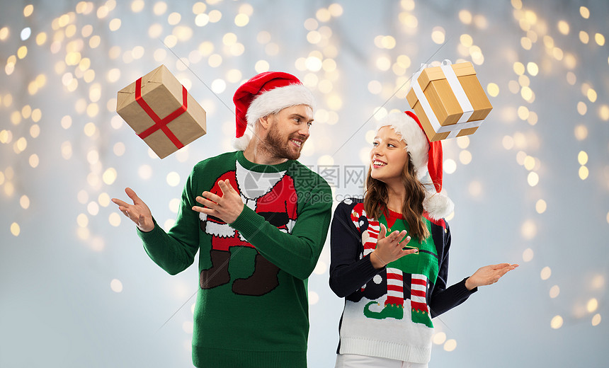 灯光背景穿着绿色毛衣诞礼物的幸福夫妇图片