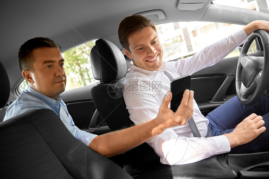 交通,出租车技术中男乘客后座向汽车司机展示他的智能手机男乘客向汽车司机展示智能手机图片