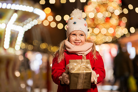 假期,童人的快乐的小女孩与礼品盒诞节市场冬季晚上诞市场上带礼品盒的快乐女孩图片