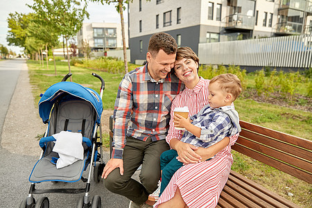 家庭,休闲人的快乐的母亲父亲,小儿子婴儿车外卖咖啡坐城市的街头长凳上家庭带着婴儿车咖啡城市图片