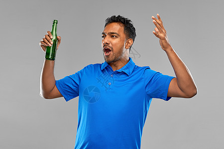 情感,表达成功情感印度男子体育迷啤酒瓶灰色背景情绪化的印度男人运动迷啤酒瓶图片