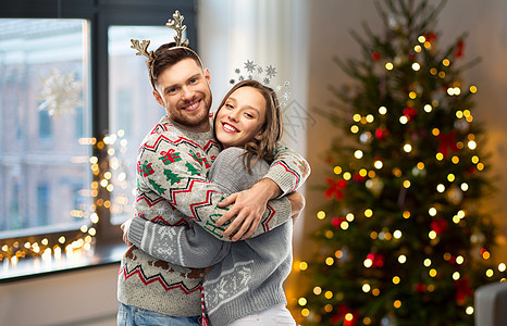 诞节,人节日的幸福的夫妇拥抱毛衣派诞丑毛衣派上的幸福夫妇图片