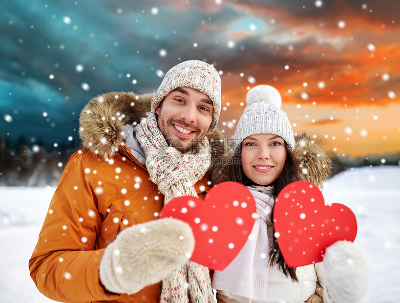 情人节,诞节假日幸福的夫妇抱着空白的红心冬天的森林背景幸福的夫妇