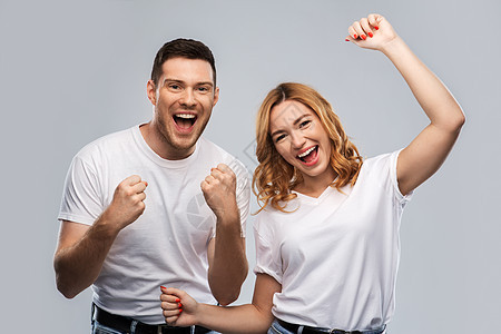 情感人的幸福的夫妇白色T恤庆祝成功的灰色背景穿着白色T恤的幸福夫妇的肖像图片