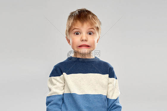 童,表情人的震惊的小男孩条纹套头衫灰色背景震惊的小男孩穿条纹套衫图片