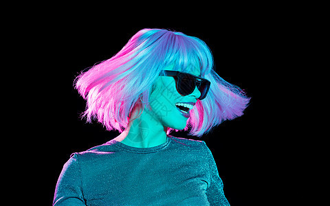 夜生活,时尚人们的快乐的轻女人戴着粉红色的假发黑色的太阳镜,紫外线黑色背景上跳舞穿着粉红色假发太阳镜跳舞的图片