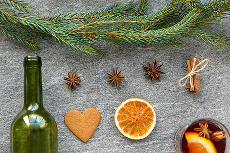 诞节季节饮料热覆盖葡萄酒,空绿色璃瓶,干橙片,姜饼芳香香料灰色背景覆盖葡萄酒,橘子片,姜饼香料图片