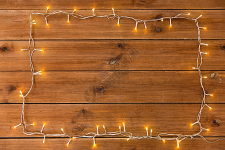 诞节,假日照明木制背景上的电动花环灯框架木制背景上的花环灯框架图片