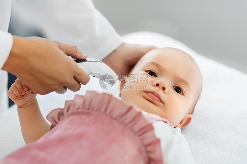 医学,医疗儿科女儿科医生与数字红外温度计测量女婴病人的耳温诊所医院带温度计的医生测量婴儿的温度图片