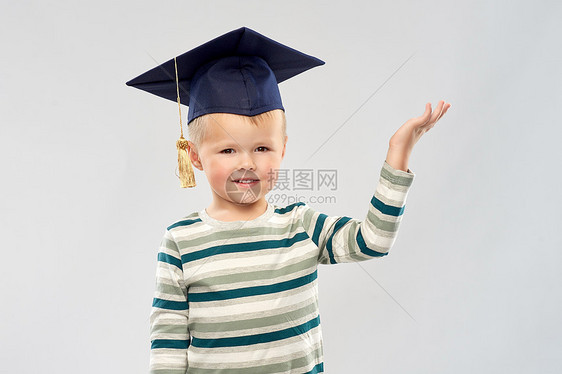 小学,学前教育儿童微笑的小男孩迫击炮板上的肖像,着些灰色背景上的空着手空手灰泥板上的小男孩图片