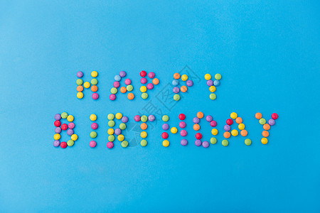 食物,糖果糖果的生日快乐刻字由糖果滴蓝色背景蓝色背景上的糖果滴生日快乐背景图片