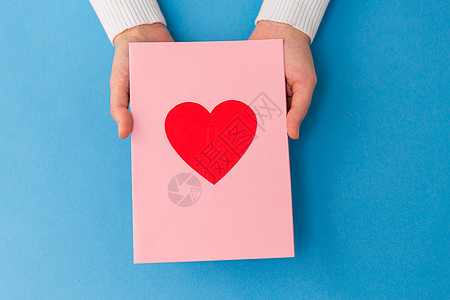 节日,爱情人节的近距离的手贺卡与心蓝色背景双手捧着贺卡图片