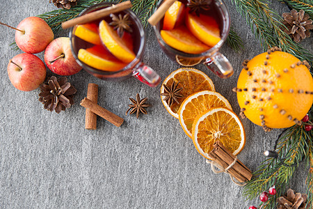 诞节季节饮食璃热覆盖葡萄酒与橙色片,姜饼饼干,苹果冷杉枝灰色背景杯热覆盖的葡萄酒,饼干,苹果冷杉图片