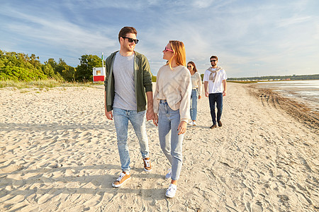 友谊休闲人的群快乐的朋友夏天沿着海滩散步快乐的朋友沿着夏天的海滩散步图片