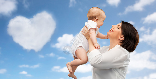 家庭,孩子父母的快乐的微笑中母亲抱着小宝贝女儿蓝天心形的云背景快乐的中母亲小女儿图片