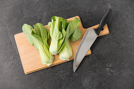蔬菜,食物烹饪Bokchoy大白菜菜刀木制切割板上的石板石背景白菜切板上的刀图片