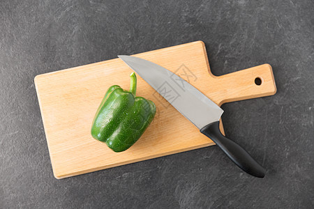 蔬菜,食物烹饪青椒菜刀木制切割板石板石背景切板上的青椒菜刀图片