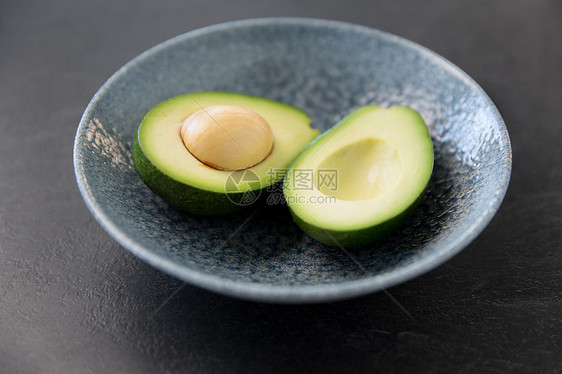 食物,饮食蔬菜的切割鳄梨与骨头陶瓷碗石板石背景把成熟的鳄梨骨头放陶瓷碗里图片