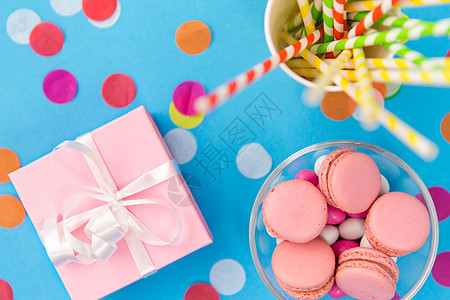 生日派,庆祝装饰礼品盒,粉红色马卡龙,纸吸管蓝色背景的纸屑生日礼物,马卡龙纸吸管参加聚会图片