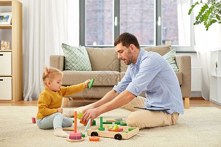 家庭,父亲人的快乐的父亲小宝贝女儿家里玩木制玩具积木套件父亲家里小女儿玩背景图片