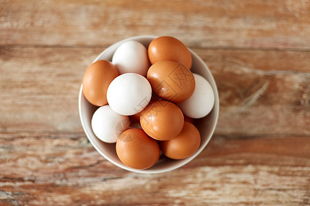 食物,烹饪烹饪天然鸡蛋陶瓷碗木制桌子上把鸡蛋放木制桌子上的陶瓷碗里图片