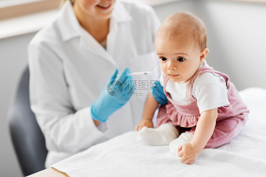 医学保健疫苗接种女儿科医生护士用注射器为临床医院的女婴病人注射疫苗医生诊所为婴儿病人制作疫苗图片