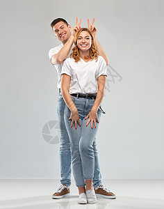 关系人的幸福的夫妇白色T恤灰色背景穿着白色T恤的幸福夫妇图片
