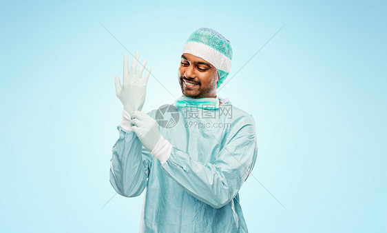 微笑的印度男医生穿着防护服戴手套图片