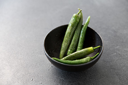 蔬菜,食物烹饪绿色辣椒陶瓷碗石板石背景把绿色辣椒关碗里图片