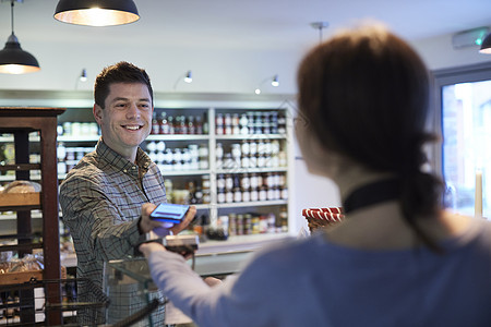 男客户熟食店用手机进行非接触式支付购物图片