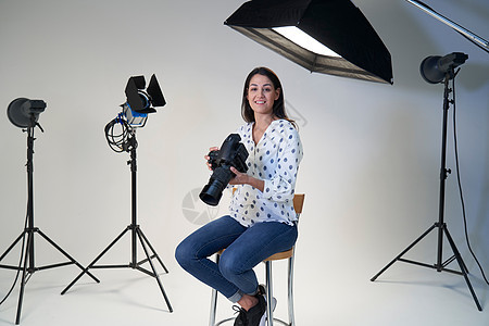 摄影室女摄影师的肖像,用相机照明设备拍摄图片