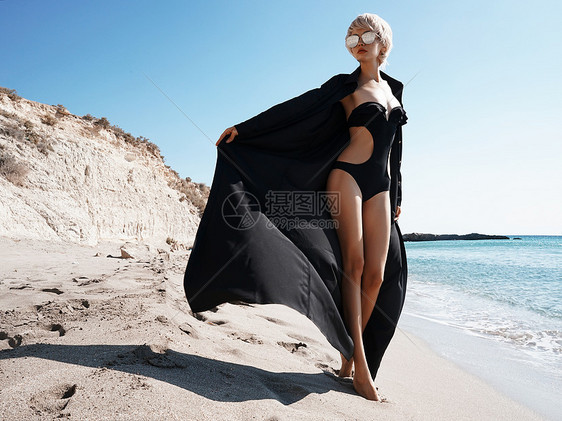 海滩上穿着黑色长袍的美丽苗条女人的户外时尚照片图片