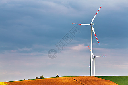 春天阳光明媚,绿色的田野里风力发电机生态动力风力涡轮机公园发电山顶上的狩猎箱下奥地利,靠近珀斯多夫图片