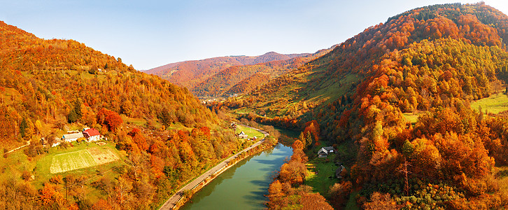 山河秋天的彩色山谷里流淌河流峡谷中道路村庄的全景阳光明媚的秋天喀尔巴阡山脉与波兰斯洛伐克,乌克兰接壤背景图片