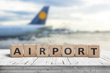 机场文字标志个木制的表上,背景架飞机图片
